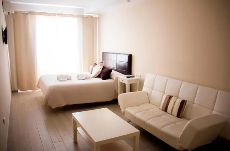 Vista general de la habitación donde pueden verse la cama de matrimonio y la zona de estar